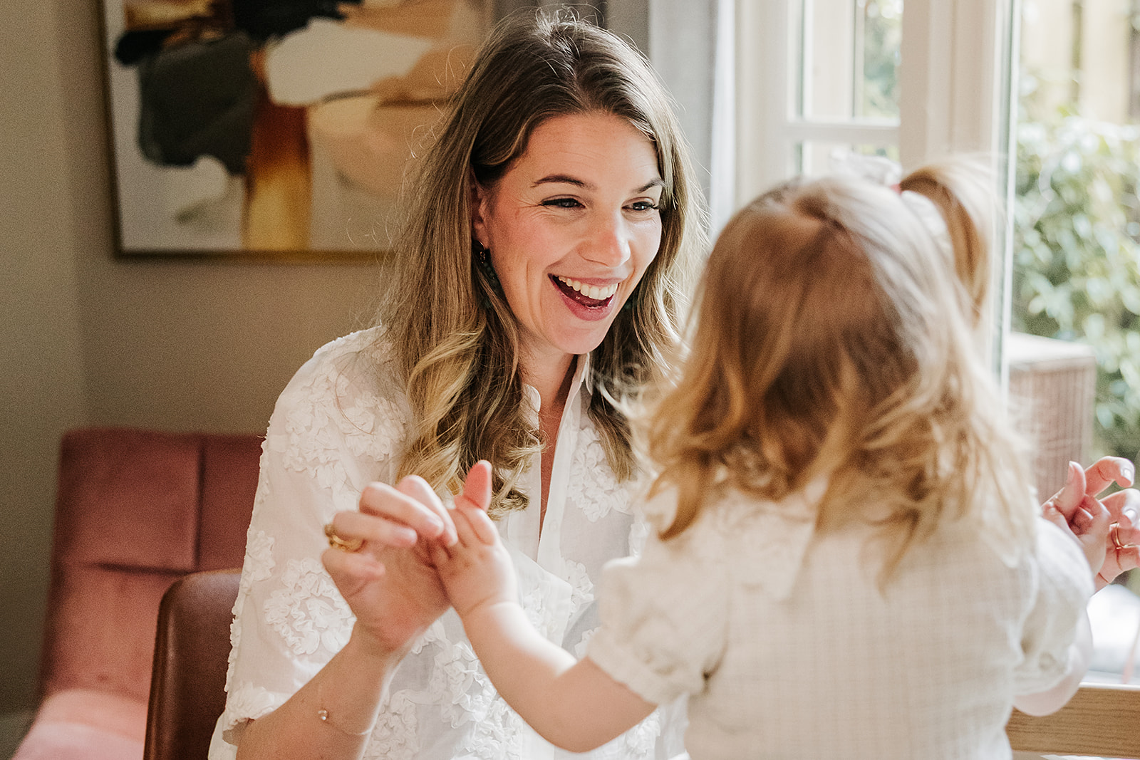 Charlotte lacht en speelt met haar dochter aan tafel